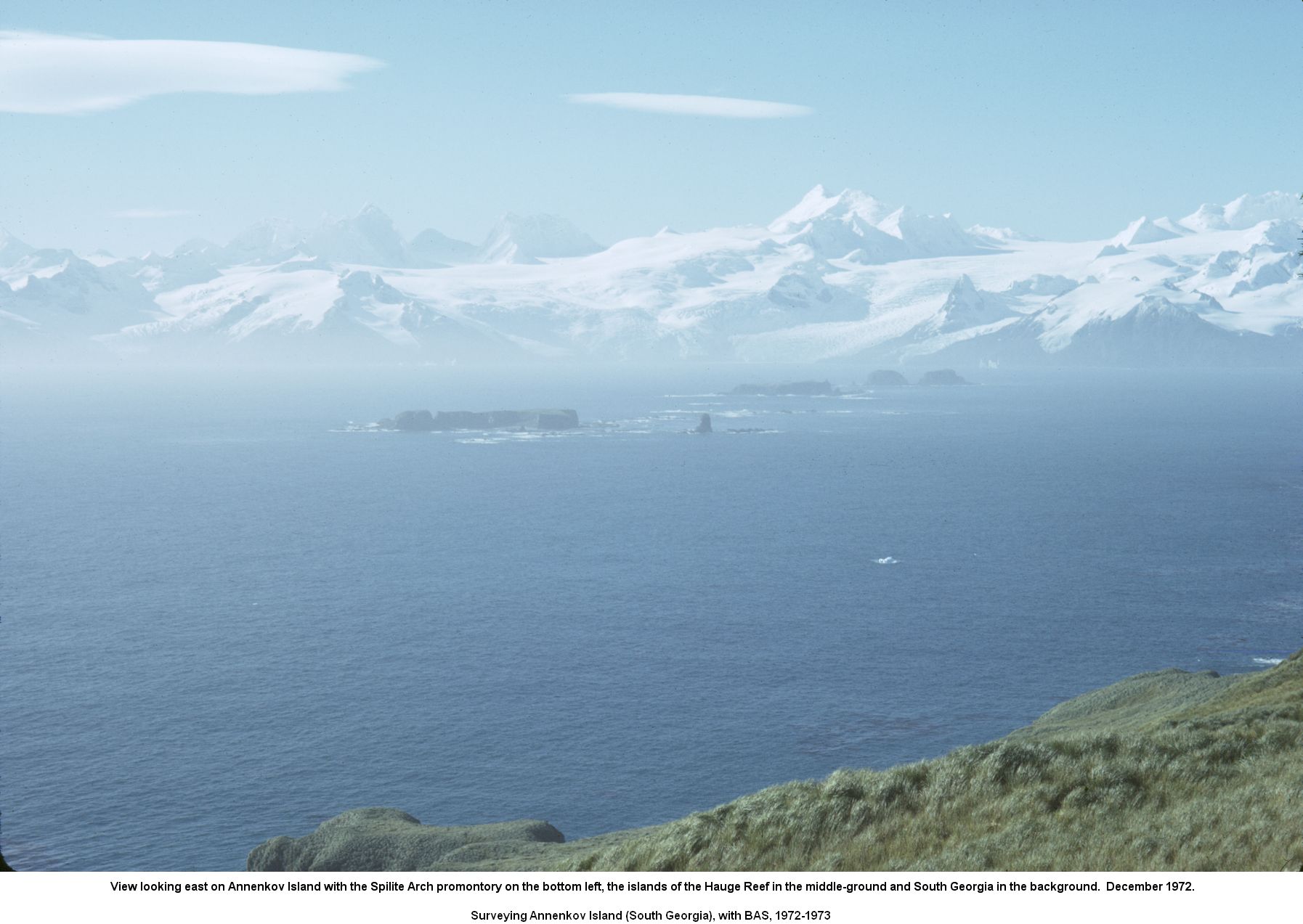 View looking east on Annenkov Island with the Spilite Arch promontory on the bottom left, the islands of the Hauge Reef in the middle-ground and South Georgia in the background.  December 1972.