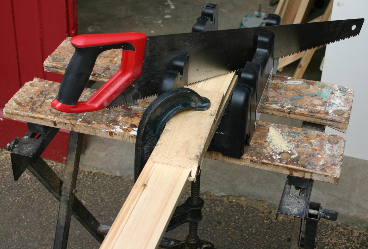 Using a mitre box to cut a mitre joint for the door architrave.