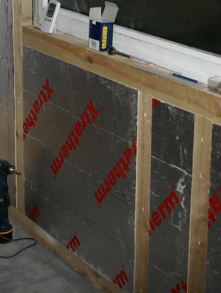 Insulation inserted in the studwork surrounding the window.