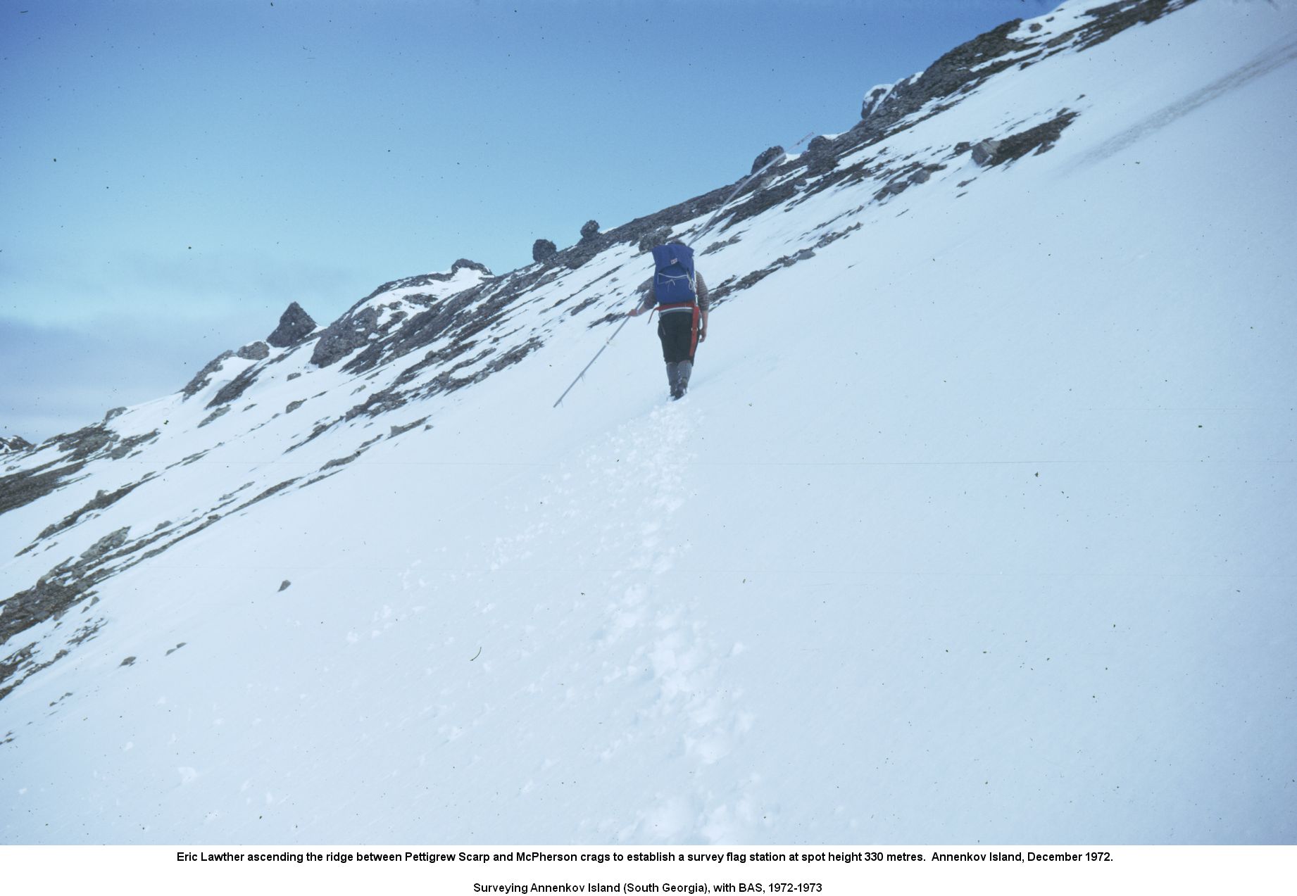 Eric Lawther ascending the ridge between Pettigrew Scarp and McPherson crags to establish a survey flag station at spot height 330 metres.  Annenkov Island, December 1972.