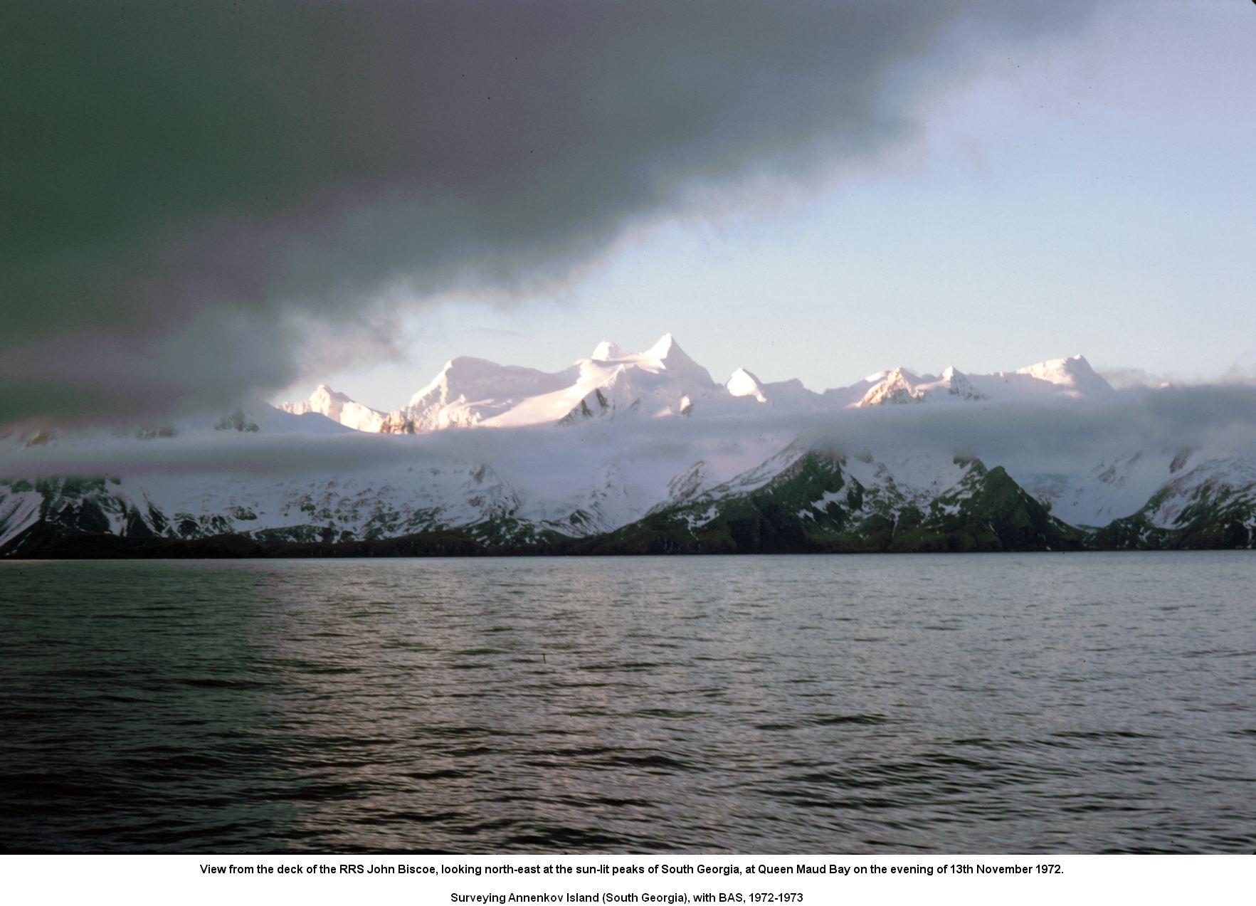 View from the deck of the RRS John Biscoe, looking north-east at the sun-lit peaks of South Georgia, at Queen Maud Bay on the evening of 13th November 1972.