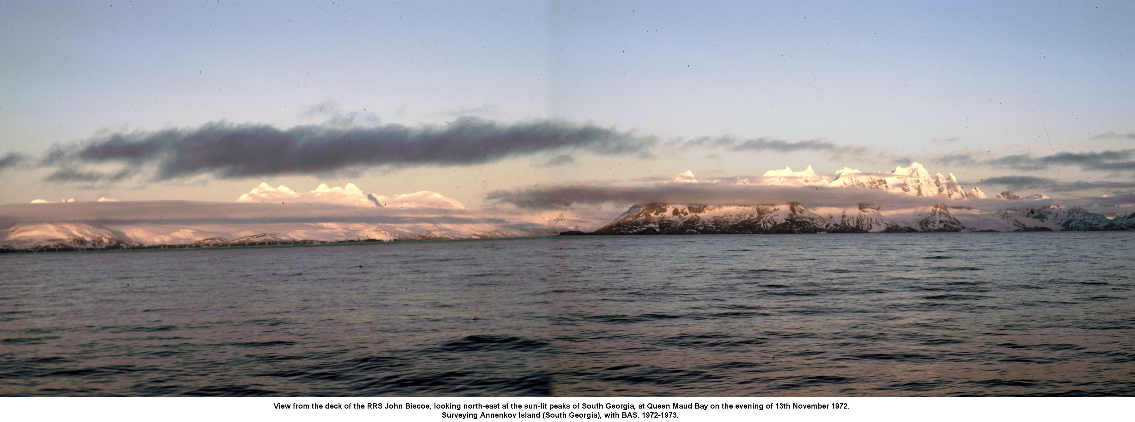 View from the deck of the RRS John Biscoe, looking north-east at the sun-lit peaks of South Georgia, at Queen Maud Bay on the evening of 13th November 1972.