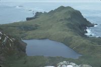 View looking due east over Fan Lake, from a view-point on the ridge to the west (at spot height 330). Albatross Crest forms the high ground on the right of the photograph, trending away towards the high cliffs at the western extremity of Annenkov Island. January 1973.