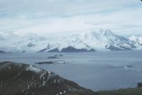 View looking north-east on Annenkov Island with Lawther Knoll in the bottom left foreground, the islands of the Hauge Reef in the middle-ground and the Allardyce Mountain Range on South Georgia in the background. December 1972.